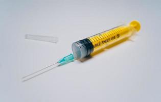 een eenmalig geel medisch injectiespuit met naald- aan het liegen foto