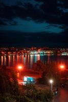 avond stad door de meer. dijk. foto