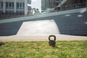 zwaar ijzer kettlebell in groen gras - buitenshuis geschiktheid concept foto