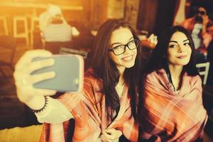 twee goede vrienden doen selfie in het café foto