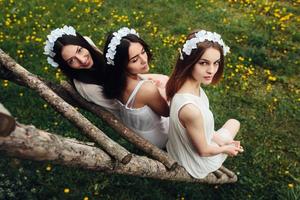 drie charmant meisjes in de buurt een houten huis foto
