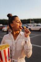 jong schattig vrouw Holding popcorn in een boodschappen doen winkelcentrum parkeren veel foto