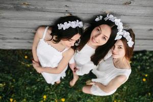 drie charmant meisjes in de buurt een houten huis foto