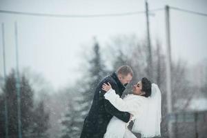 bruid en bruidegom lopen op de Europese stad in de sneeuw foto