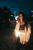 jong vrouw met zaklamp Aan de strand Bij nacht foto