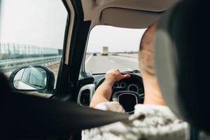 de Mens in de auto op reis Aan de weg foto