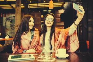 twee dichtbij vrienden maken selfie in de cafe foto