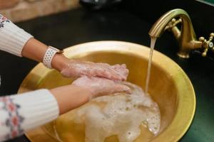 dichtbij omhoog foto van vrouw wast haar handen met zeep en water.