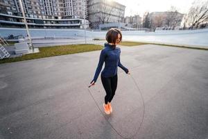 jong vrouw oefening met overslaan touw buitenshuis foto