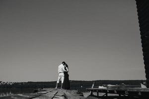 knuffelen Mens en vrouw in liefde Aan houten pier foto