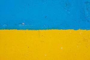beton muur geschilderd in geel en blauw Leuk vinden oekraïens vlag, de land van slachtoffer van de agressor foto