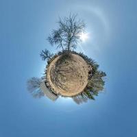 klein planeet in verlaten dorp in de buurt oud huis in blauw lucht met mooi wolken. transformatie van bolvormig panorama 360 graden. bolvormig abstract antenne visie. kromming van ruimte. foto