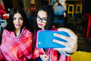 twee goede vrienden doen selfie in het café foto