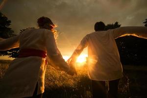 paar rennen naar de zonsondergang foto