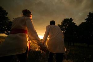 paar rennen naar de zonsondergang foto