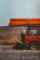 Mens leugens onder een 4x4 auto Aan een aarde weg foto