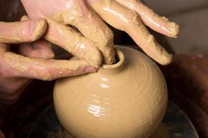 handen van een pottenbakker, waardoor een aarden pot ontstaat