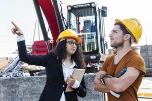 jonge vrouwelijke ingenieur vertelt over het werken met een werknemer