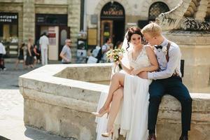 bruid en bruidegom poseren Bij de fontein foto