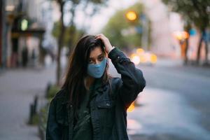 jong vrouw, persoon in beschermend medisch steriel masker Bij leeg straat foto