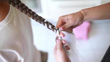 werkwijze van vlechten. meester weeft vlechtjes Aan hoofd in een schoonheid salon, dichtbij omhoog foto