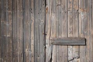 achtergrond en detail van een oud verweerd Gesloten houten deur dat is in landschap formaat in een oud muur. foto