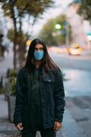 jong vrouw, persoon in beschermend medisch steriel masker Bij leeg straat foto