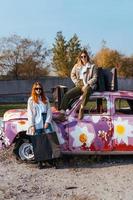 jong Dames poseren in de buurt een oud versierd auto foto