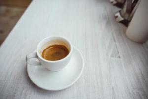 kop van cappuccino Aan de wit houten tafel. foto