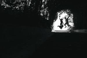 paar jumping in de einde van tunnel met bomen foto