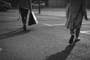 jong Dames met boodschappen doen Tassen wandelen Aan straat. foto
