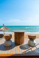 hout tafel stoel en stoel met zee strand achtergrond foto