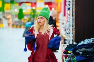 jong vrouw kiezen hoed in boodschappen doen centrum foto