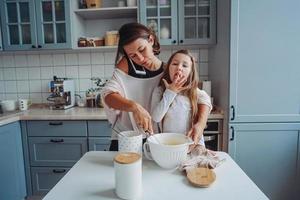 mam geeft les haar weinig dochter naar koken voedsel foto