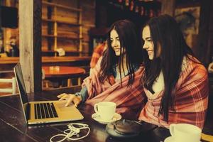 twee meisjes kijken naar iets in de laptop foto