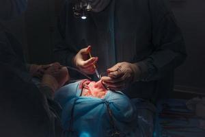 chirurg en zijn assistent het uitvoeren van kunstmatig chirurgie Aan neus- foto