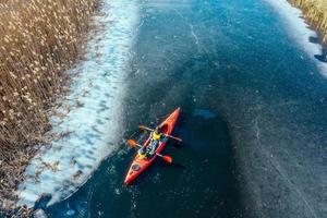 twee atletisch Mens drijft Aan een rood boot in rivier- foto