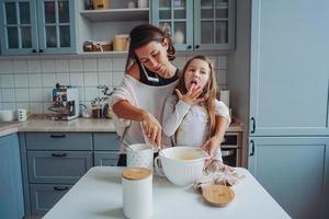 mam geeft les haar weinig dochter naar koken voedsel foto