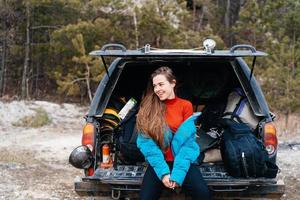 jong vrouw genieten van natuur terwijl zittend in de auto romp foto