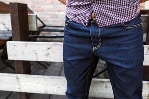 lager lichaam van mannen gekleed in zelfkant jeans , retro schoenen en plaid shirt. foto