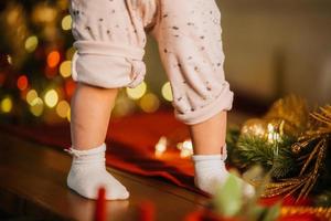 schattig weinig baby poten in kamer met Kerstmis boom foto