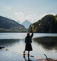 de meisje in de jurk en hoed van de meer in de bergen foto