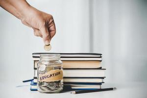 detailopname onderwijs voorwerp met stack geld muntgeld dollar en glas pot Aan achtergrond. concept naar besparing geld inkomen voor studie, berekenen leerling financiën kosten en investering begroting lening foto