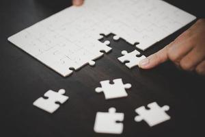 bedrijf vrouw persoon hand- met puzzel stuk idee voor strategie en oplossing. detailopname een deel van twee wit decoupeerzaag aansluiten samen. concept van toetreden samenwerking succes teamwork-probleem zakelijke team. foto