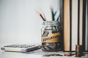 detailopname onderwijs voorwerp met stack geld muntgeld dollar en glas pot Aan achtergrond. concept naar besparing geld inkomen voor studie, berekenen leerling financiën kosten en investering begroting lening foto