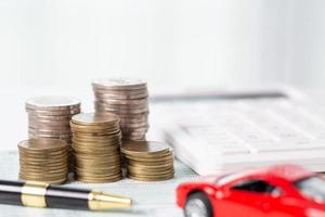 auto speelgoed- voertuig met stack munt geld Aan achtergrond. planning naar beheren vervoer financiën kosten. concept van auto verzekering bedrijf, besparing kopen - uitverkoop met belasting en lening voor nieuw auto. foto