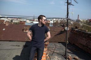 de man in de authentieke zelfkant van laarzen en jeans op het dak van het gebouw in de oude stad foto