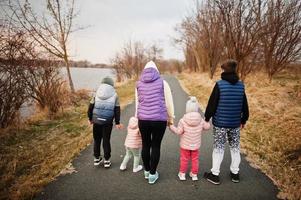 achterkant van moeder wandelen met kinderen op het pad bij het meer. foto