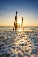 gebroken houten brug zonsondergang Aan de zee Bij phangnga, Thailand foto