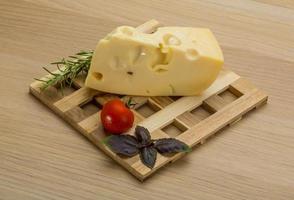 maasdam kaas Aan houten bord en houten achtergrond foto